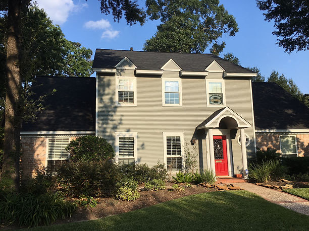 New architectural shingle roof on a two-story Houston home with a red front door
