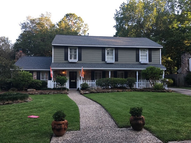 New roof on a classic colonial home with a white picket fence in Houston